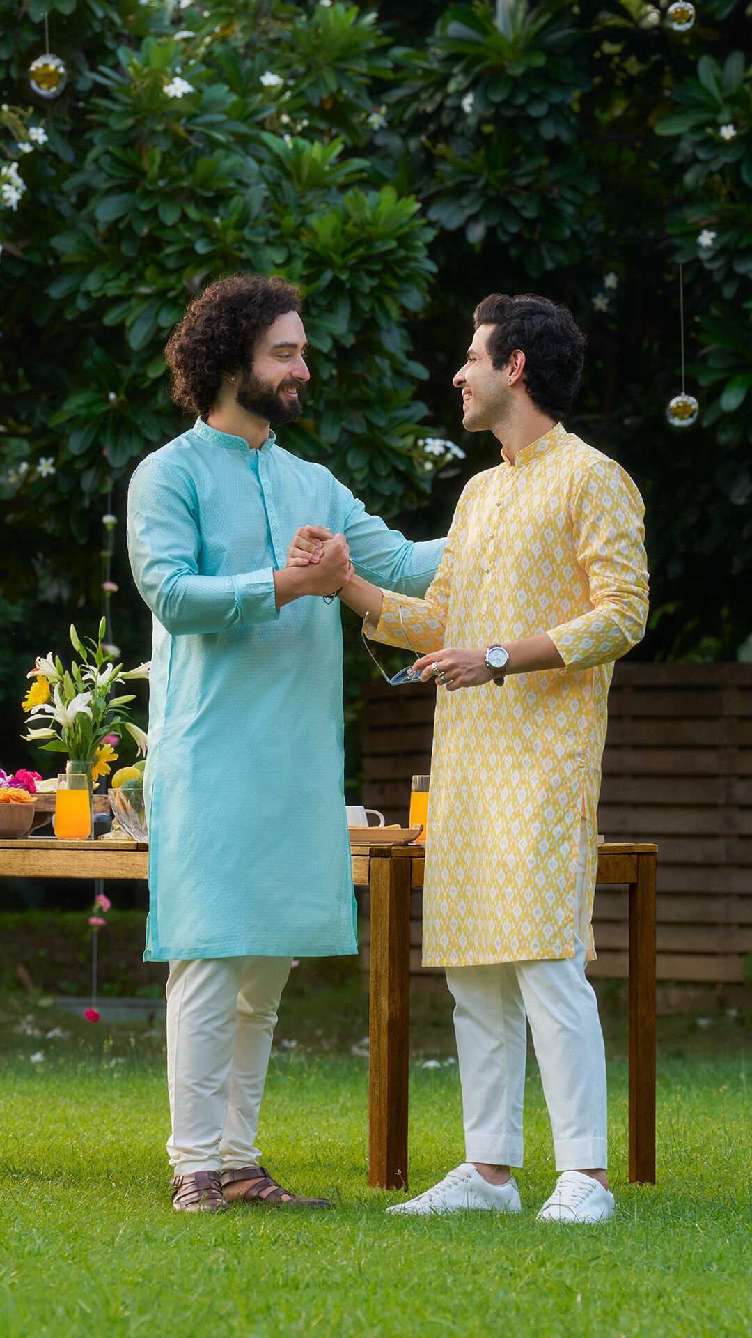 Two men wearing handcrafted kurtas in soft natural hues highlight sustainable fashion, artisanal textiles, and conscious festive dressing.